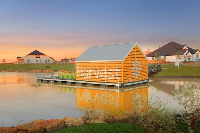 view of dock with a water view and a yard