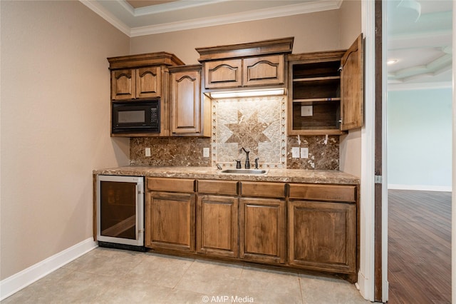 kitchen with crown molding, backsplash, beverage cooler, a sink, and black microwave