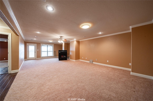 unfurnished living room with dark carpet, ornamental molding, a ceiling fan, a textured ceiling, and baseboards