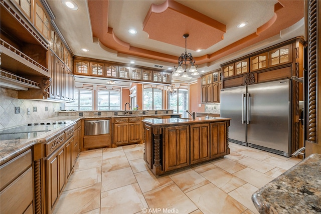 kitchen with built in fridge, plenty of natural light, a raised ceiling, and a warming drawer