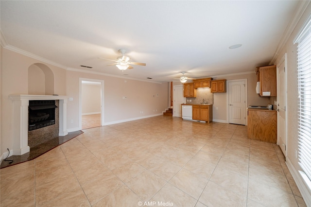 unfurnished living room featuring baseboards, a premium fireplace, visible vents, and crown molding