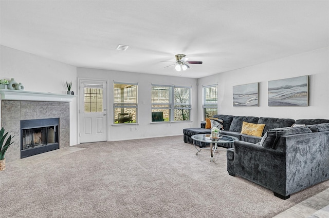 living room with visible vents, baseboards, carpet, a fireplace, and a ceiling fan