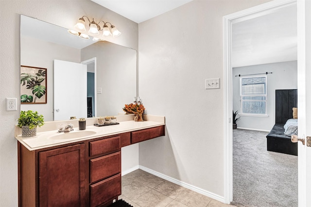 ensuite bathroom with vanity, tile patterned floors, baseboards, and connected bathroom