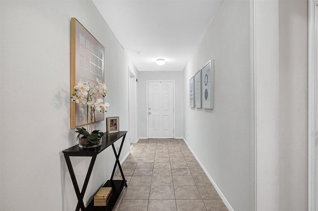 hallway featuring light tile patterned flooring and baseboards