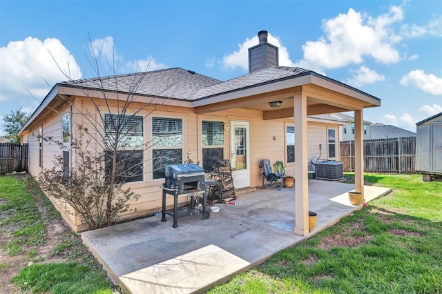 rear view of property featuring a patio, fence, a lawn, and a chimney