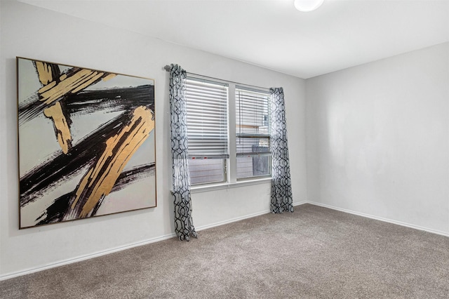 spare room featuring baseboards and carpet floors