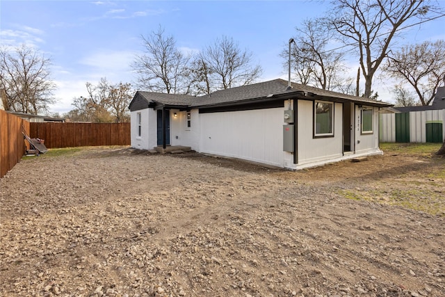 view of front of house with fence and roof with shingles