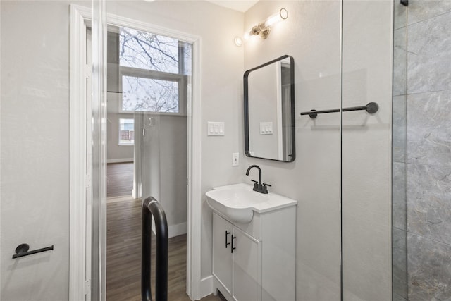 bathroom with baseboards, wood finished floors, and vanity