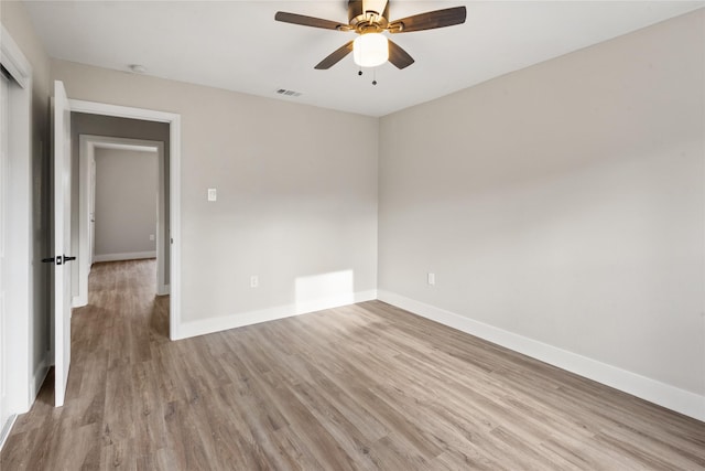 spare room with light wood-style floors, baseboards, and visible vents