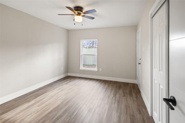 unfurnished bedroom featuring a closet, ceiling fan, baseboards, and wood finished floors