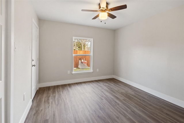 empty room with a ceiling fan, baseboards, and wood finished floors