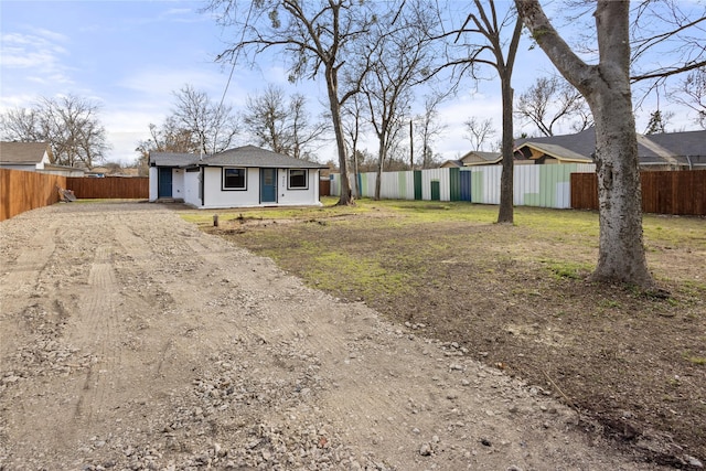 view of front facade with fence and dirt driveway