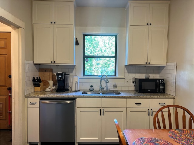 kitchen with black microwave, stainless steel dishwasher, a sink, and white cabinets