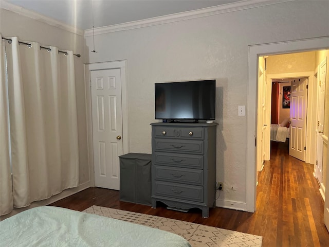 bedroom featuring ornamental molding, dark wood finished floors, and baseboards