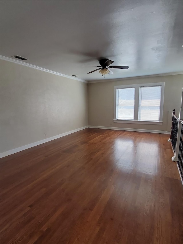 unfurnished room with ornamental molding, wood finished floors, visible vents, and baseboards