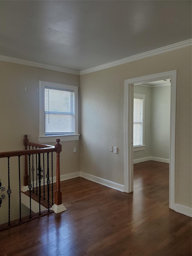 unfurnished room featuring ornamental molding, wood finished floors, and baseboards