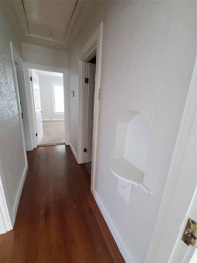 hall with attic access, baseboards, and wood finished floors