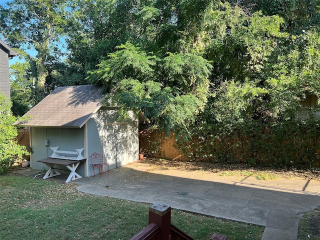 view of yard featuring an outbuilding, a shed, and fence