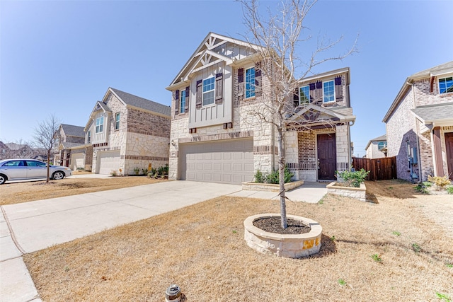 view of front of property with driveway, a garage, stone siding, fence, and board and batten siding