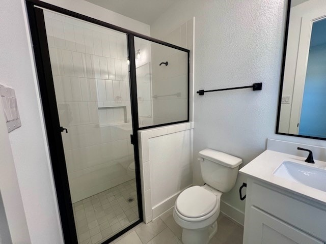 bathroom with baseboards, a shower stall, toilet, and vanity