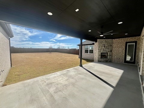 view of patio / terrace featuring a ceiling fan, a fenced backyard, and exterior fireplace