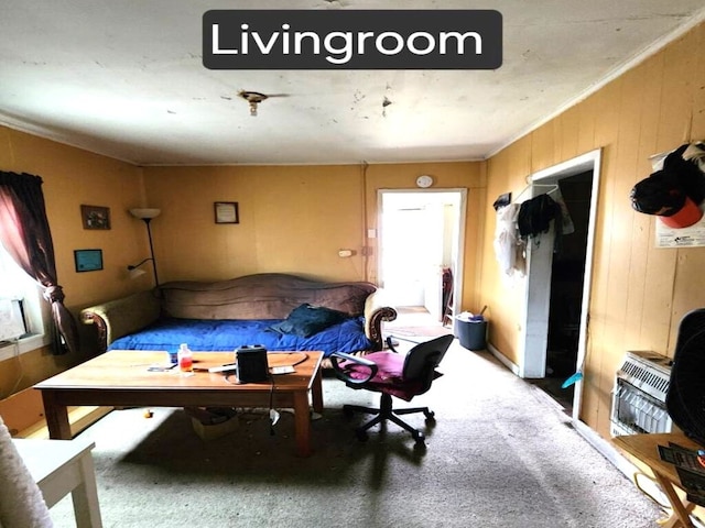 carpeted living area featuring ornamental molding, wooden walls, and heating unit