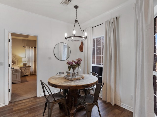 dining room featuring a chandelier, dark wood finished floors, visible vents, and baseboards