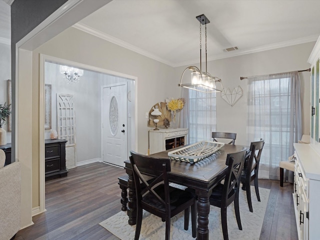 dining room featuring dark wood-style flooring, visible vents, and crown molding