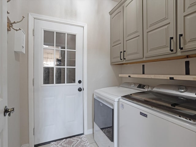 laundry area featuring cabinet space, washing machine and clothes dryer, and light tile patterned flooring