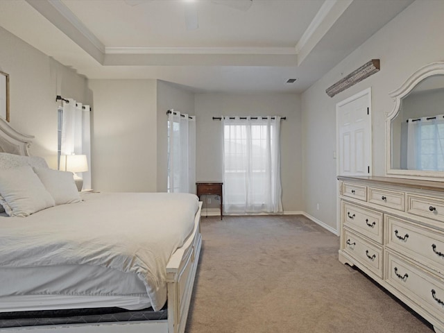 bedroom featuring light carpet, baseboards, a raised ceiling, ceiling fan, and ornamental molding