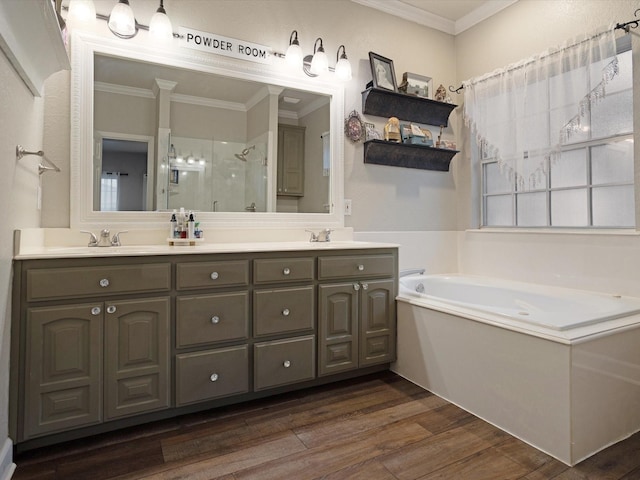 bathroom with a garden tub, a sink, wood finished floors, a stall shower, and crown molding