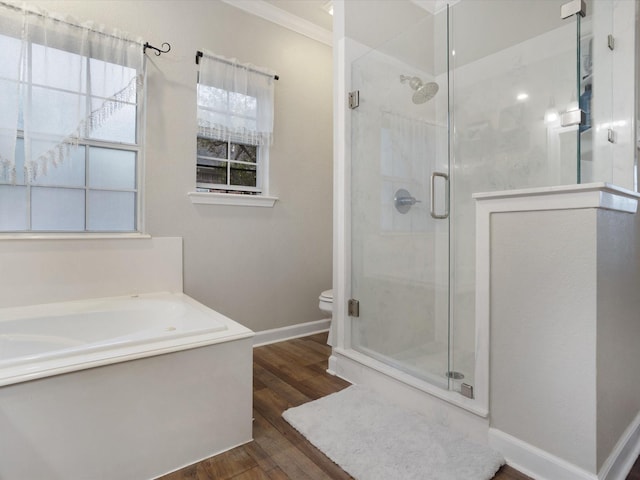 bathroom featuring wood finished floors, a shower stall, a bath, and baseboards