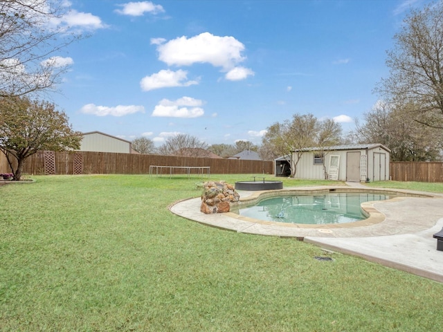 view of pool with an outbuilding, a storage unit, a lawn, and a fenced backyard