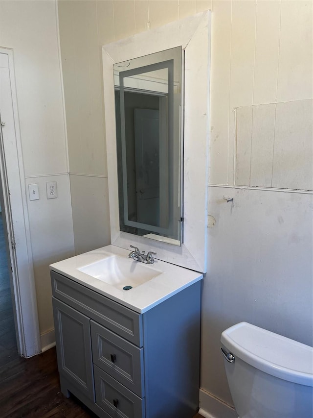 bathroom with vanity, toilet, and wood finished floors