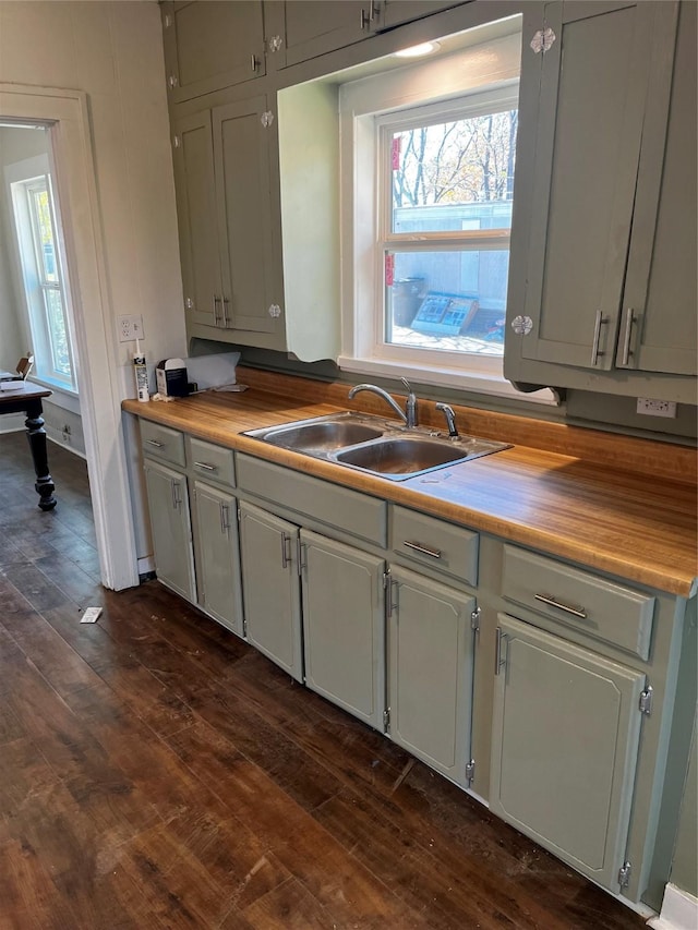 kitchen with a wealth of natural light, dark wood-style flooring, light countertops, and a sink