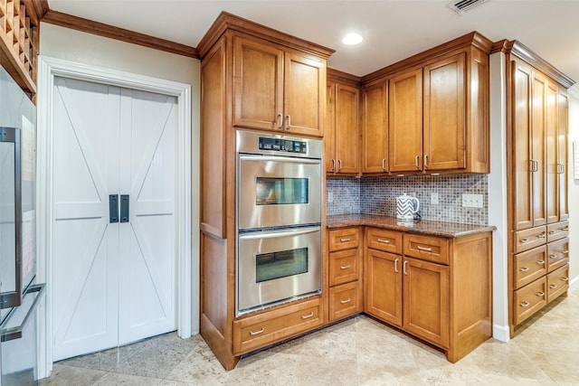 kitchen featuring double oven, brown cabinetry, and stone countertops