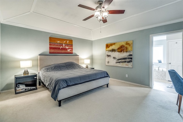 carpeted bedroom with a raised ceiling, ensuite bathroom, ornamental molding, a ceiling fan, and baseboards