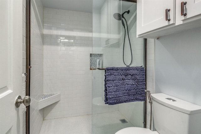 bathroom featuring a stall shower and toilet