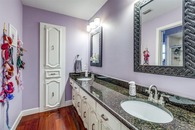 full bath featuring visible vents, a sink, baseboards, and wood finished floors