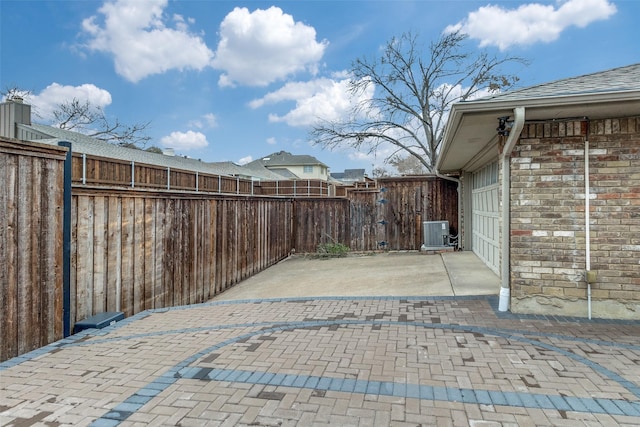 view of patio / terrace with a garage, fence, and central air condition unit