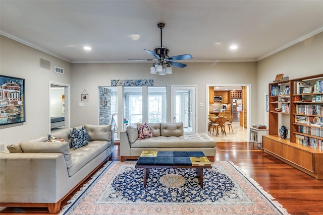 living room featuring ornamental molding, recessed lighting, visible vents, and wood finished floors