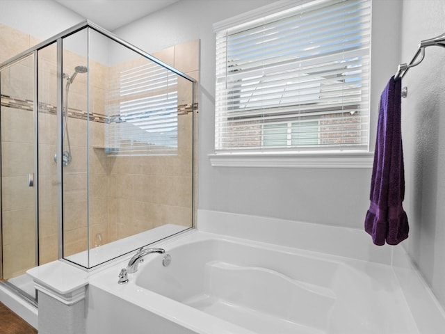 bathroom featuring a stall shower and a garden tub