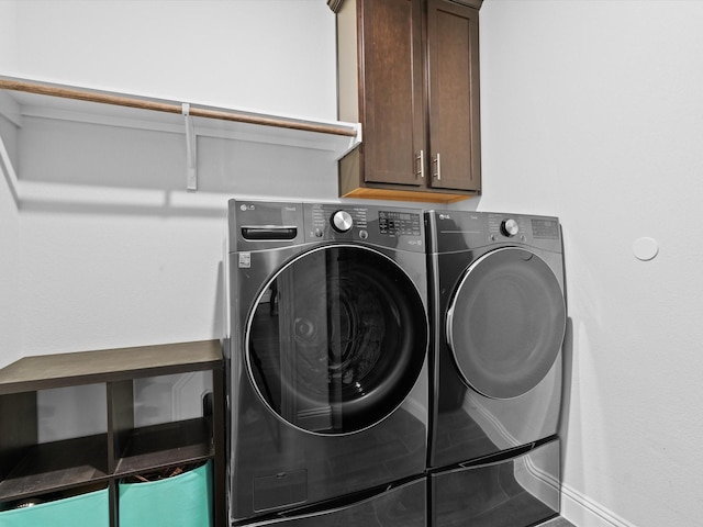 washroom with washing machine and dryer and cabinet space