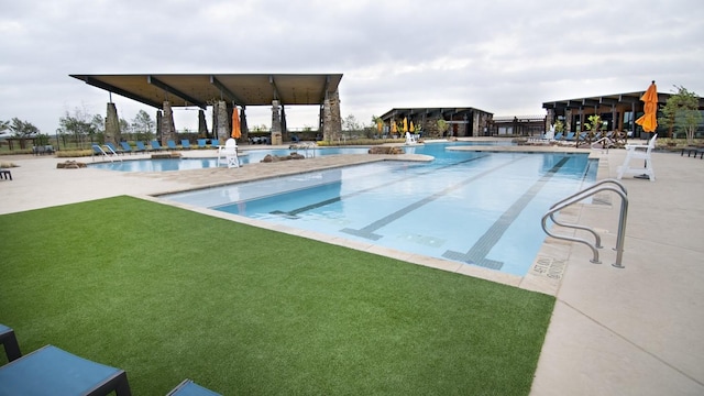 community pool with a patio area and a yard