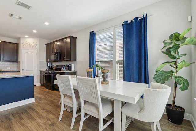 dining area featuring baseboards, visible vents, and wood finished floors