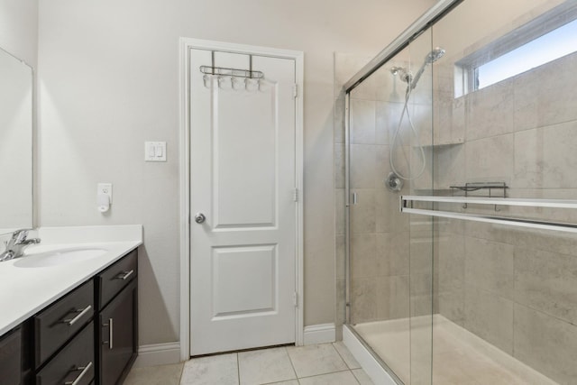 bathroom featuring a stall shower, vanity, baseboards, and tile patterned floors