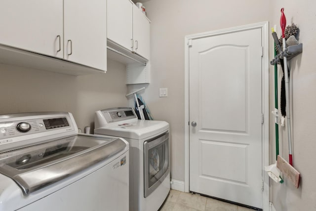 laundry area featuring cabinet space, separate washer and dryer, and light tile patterned flooring