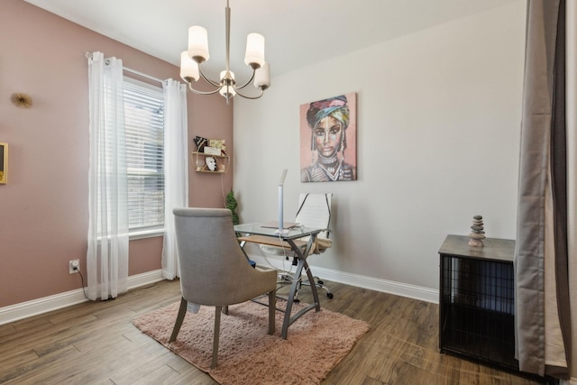 dining area with a chandelier, baseboards, and wood finished floors