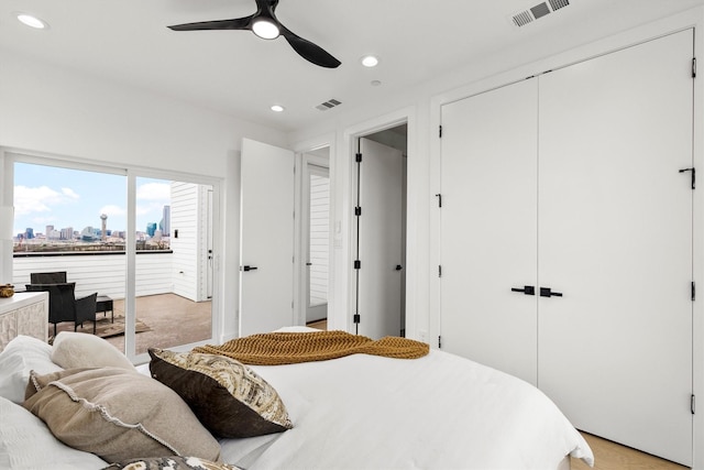 bedroom with access to outside, recessed lighting, visible vents, and a city view