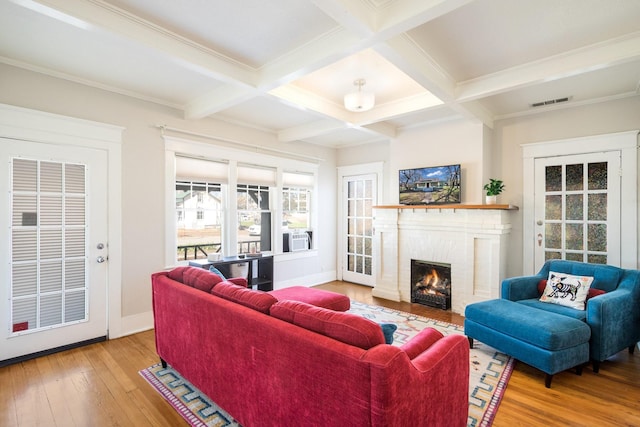 living room with a brick fireplace, wood-type flooring, coffered ceiling, and beam ceiling